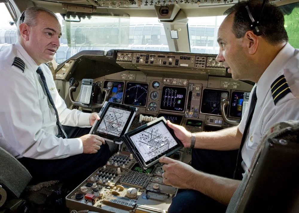 Two pilots looking at airport diagrams on their iPads